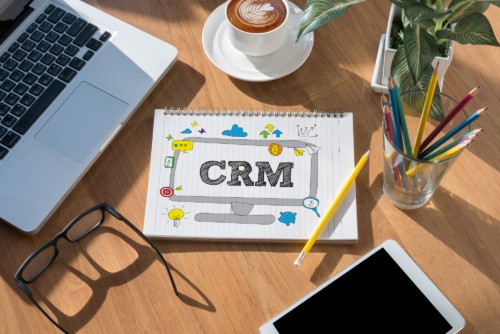 notebook showing "crm" on desk enefits of zoho crm with virtual assistants