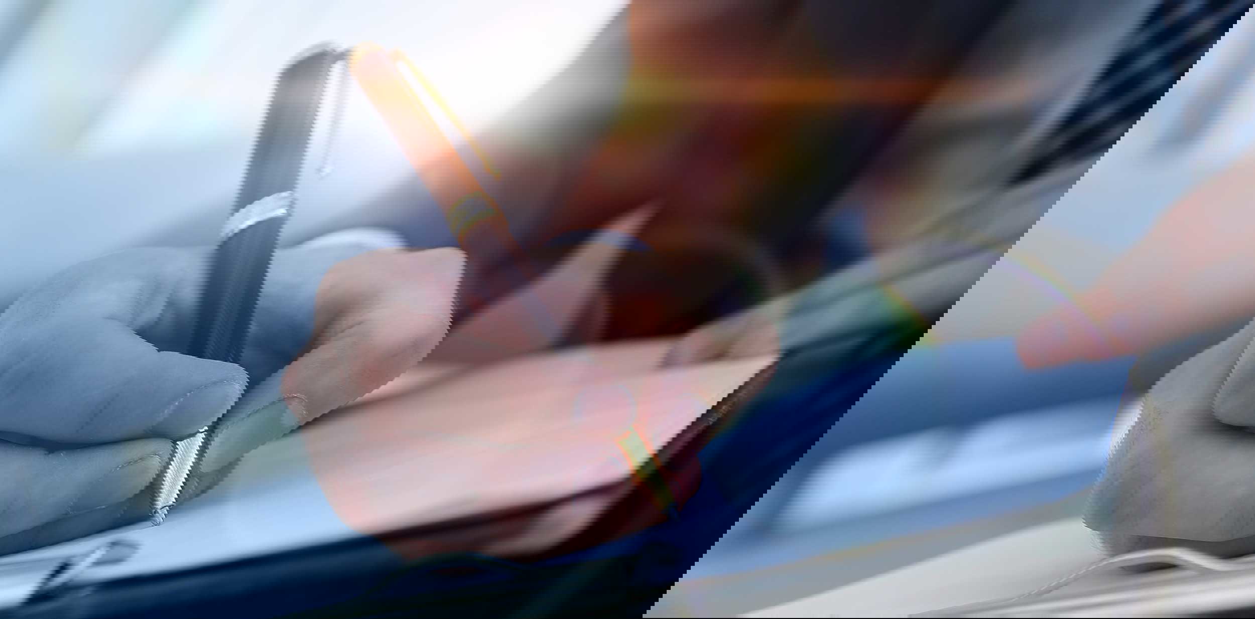 person writing in a notebook Mortgage Virtual Assistants