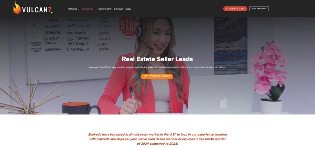 A woman in a red blazer sits at a desk with papers and a laptop, smiling and writing. The Vulcan7 website header offers 2025’s best Real Estate CRM seller leads, with a highlighted “GET STARTED TODAY” button in the center.