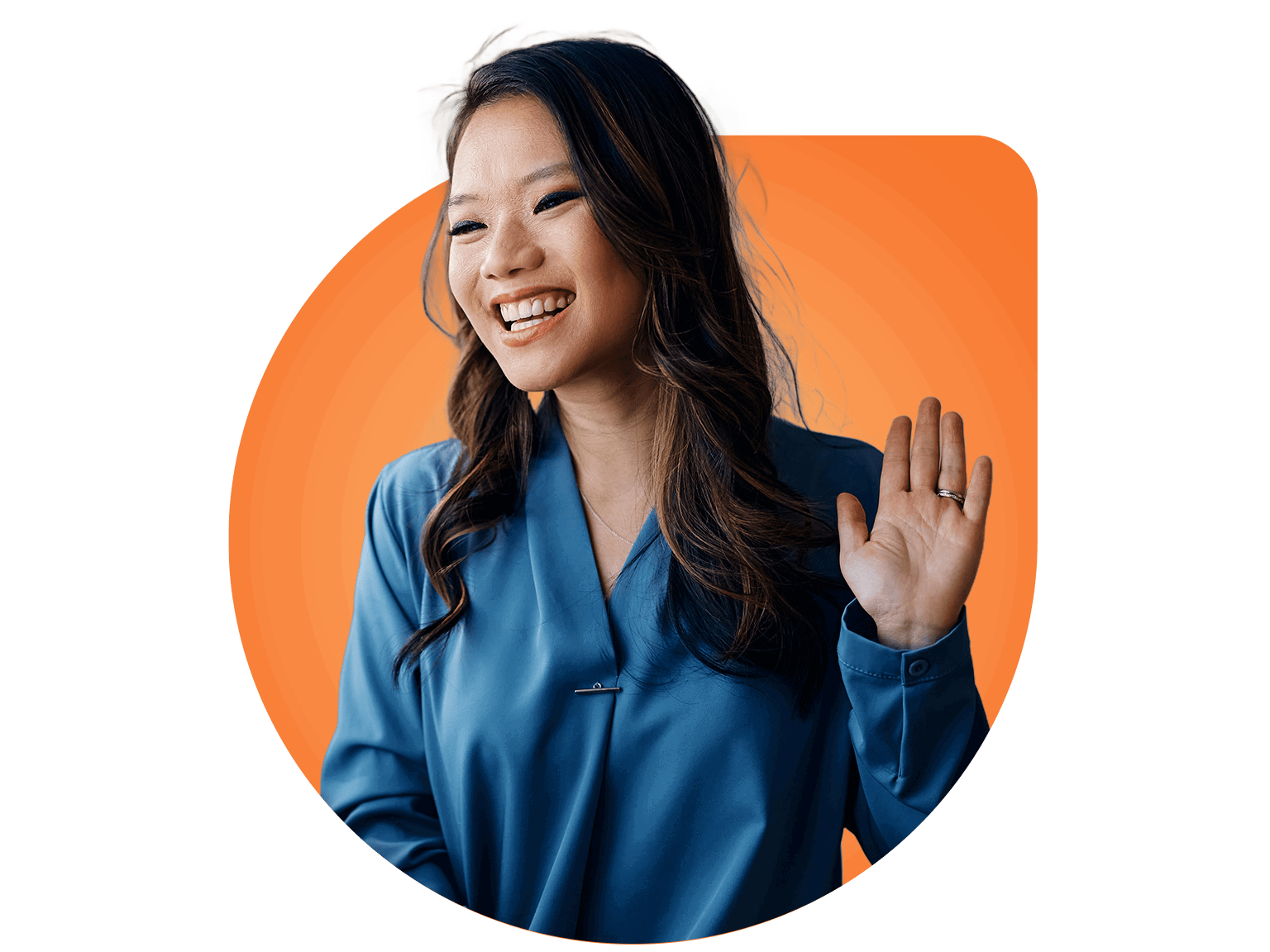 A smiling woman with long dark hair wearing a blue blouse raises her hand in a friendly gesture, standing in front of an orange background—ready to help as your Virtual Personal Assistant.